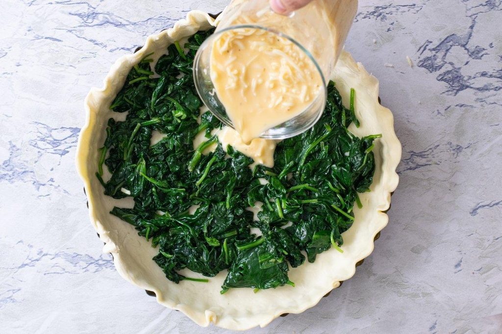 Mezcla de espinacas, huevo, crema y queso para preparar un quiche.